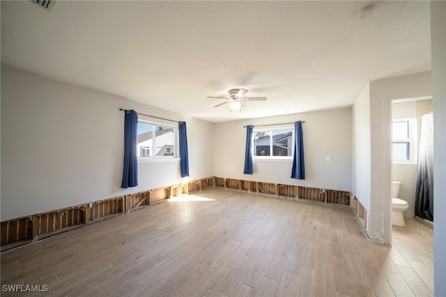 unfurnished room with ceiling fan, a healthy amount of sunlight, and light wood-type flooring