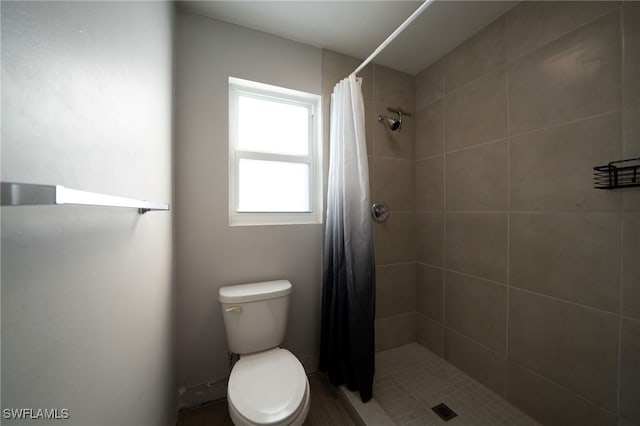 bathroom with toilet and a shower with shower curtain