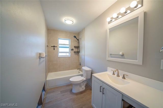 full bathroom featuring hardwood / wood-style flooring, tiled shower / bath, vanity, and toilet