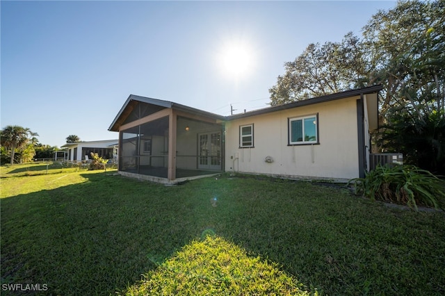 back of property featuring a sunroom and a yard