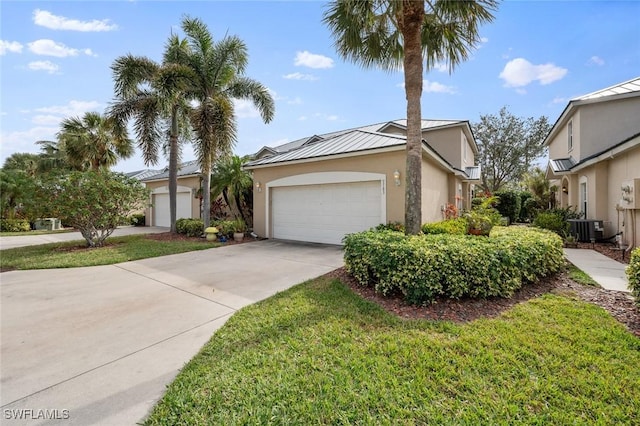 view of front of property with a garage, central air condition unit, and a front lawn