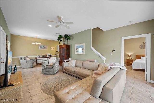 living room with light tile patterned floors and ceiling fan with notable chandelier