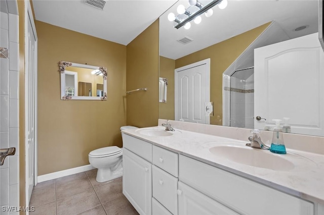 bathroom featuring toilet, vanity, tile patterned floors, and a shower with shower door