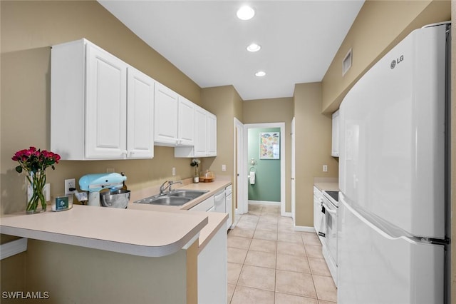 kitchen featuring white appliances, white cabinets, sink, light tile patterned flooring, and kitchen peninsula