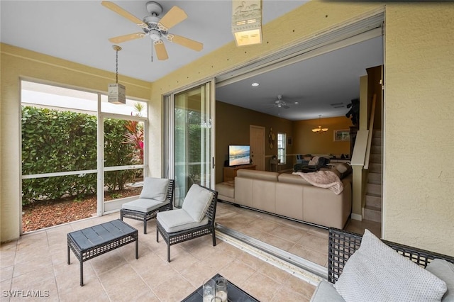 sunroom featuring ceiling fan