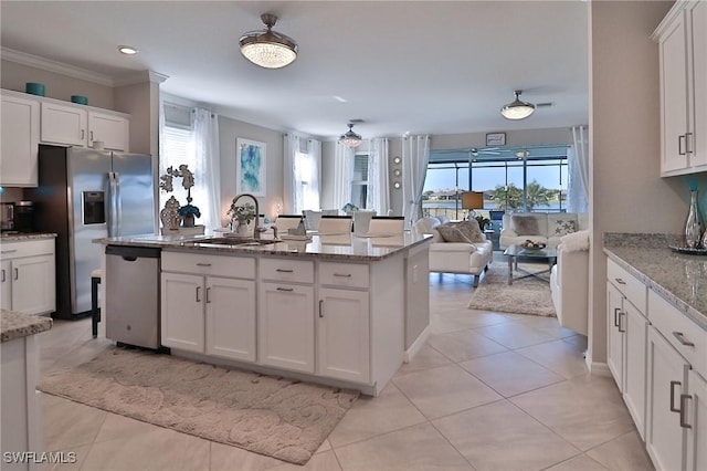 kitchen with light stone counters, sink, white cabinets, and stainless steel appliances