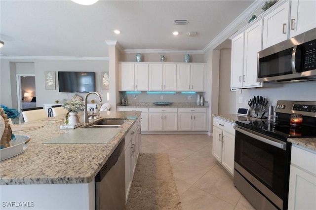 kitchen with stainless steel appliances, a kitchen island with sink, white cabinets, and sink