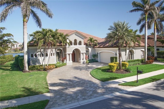 mediterranean / spanish-style home featuring a front yard and a garage