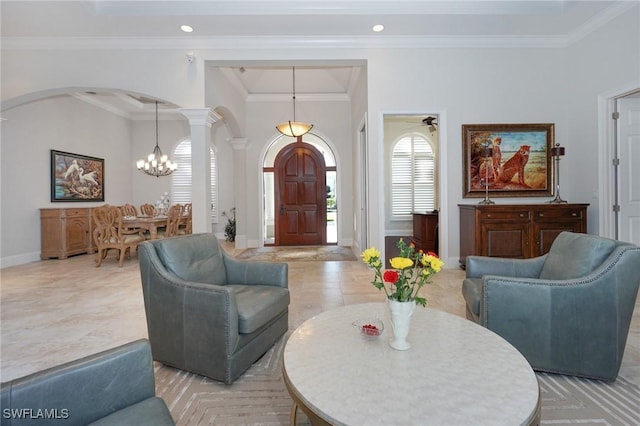 living room featuring ornate columns, crown molding, and ceiling fan with notable chandelier