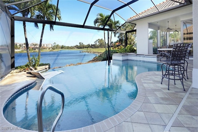 view of pool with ceiling fan, a water view, a patio, and glass enclosure