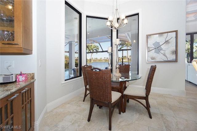 dining space with a notable chandelier and a water view