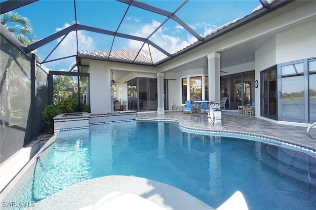 view of pool with glass enclosure, ceiling fan, and a patio