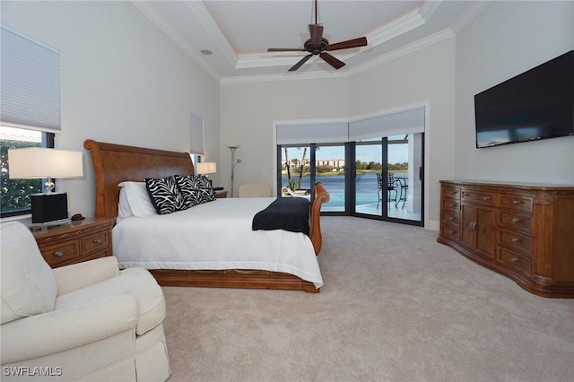 carpeted bedroom featuring a high ceiling, ceiling fan, access to exterior, ornamental molding, and a tray ceiling