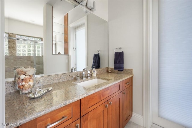 bathroom featuring a shower with door and vanity