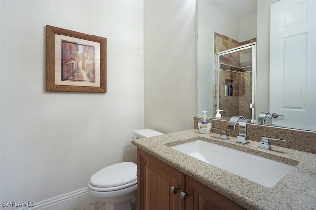 bathroom with vanity, toilet, and a shower with door