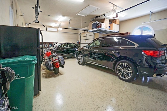 garage featuring black fridge and a garage door opener