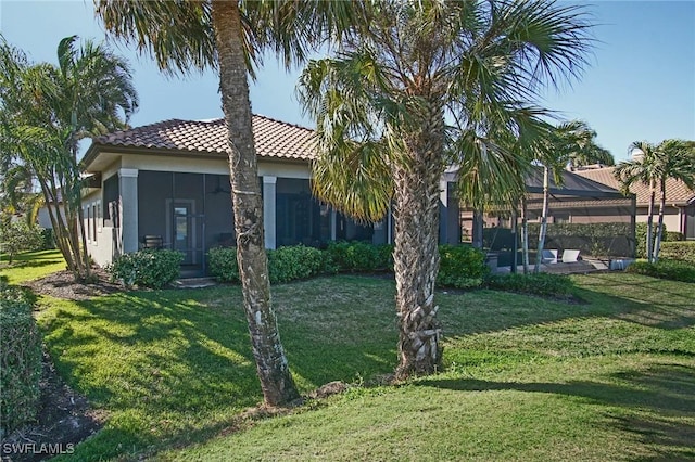 exterior space with a lawn, a sunroom, and a patio area