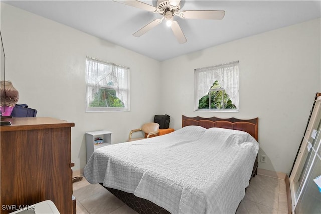 bedroom with ceiling fan and light tile patterned flooring