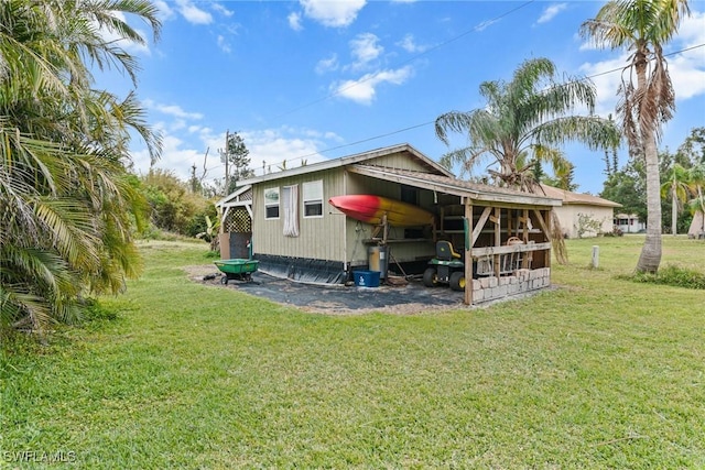 rear view of property featuring a lawn