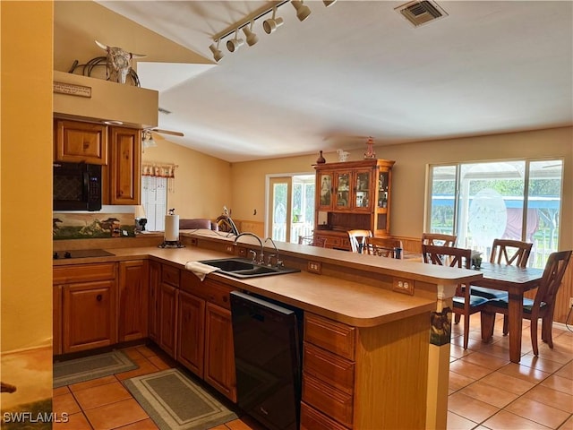 kitchen with black appliances, kitchen peninsula, sink, and vaulted ceiling