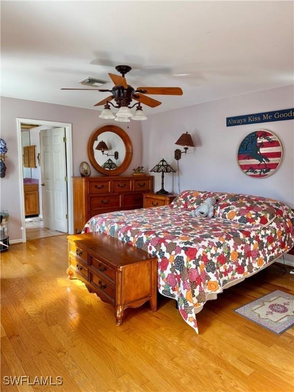 bedroom featuring ensuite bath, light hardwood / wood-style flooring, and ceiling fan