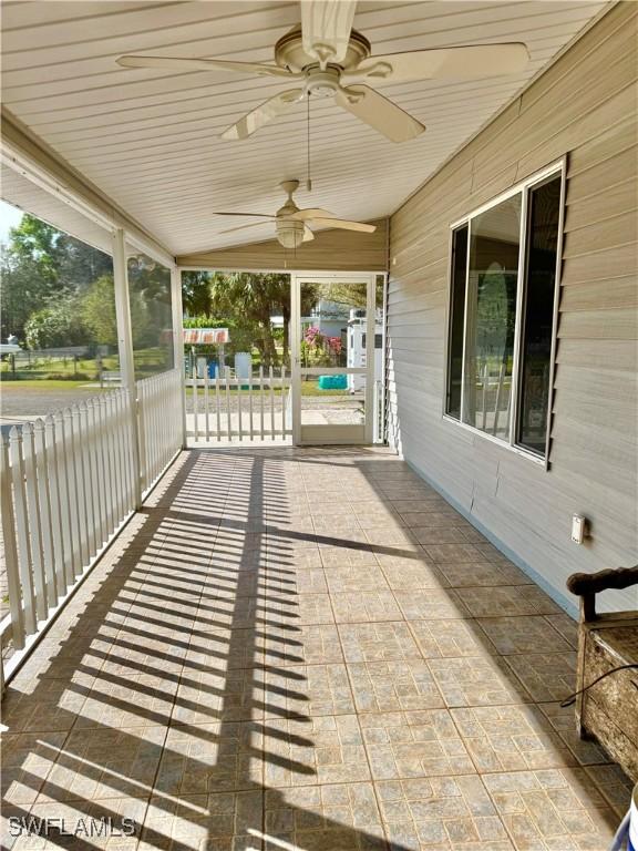 unfurnished sunroom featuring ceiling fan