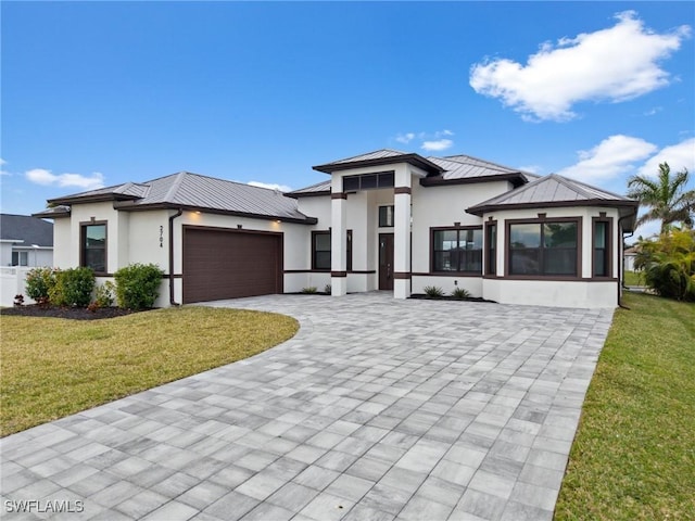 prairie-style home with a front lawn and a garage