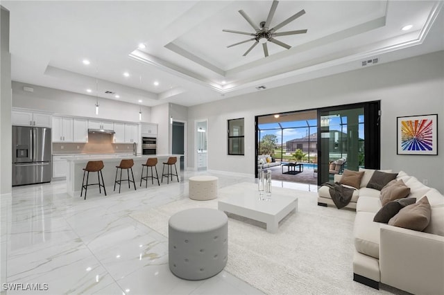 living room featuring a raised ceiling and a towering ceiling