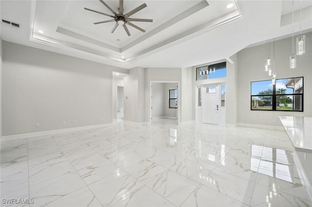 unfurnished living room with a tray ceiling, ornamental molding, a towering ceiling, and ceiling fan