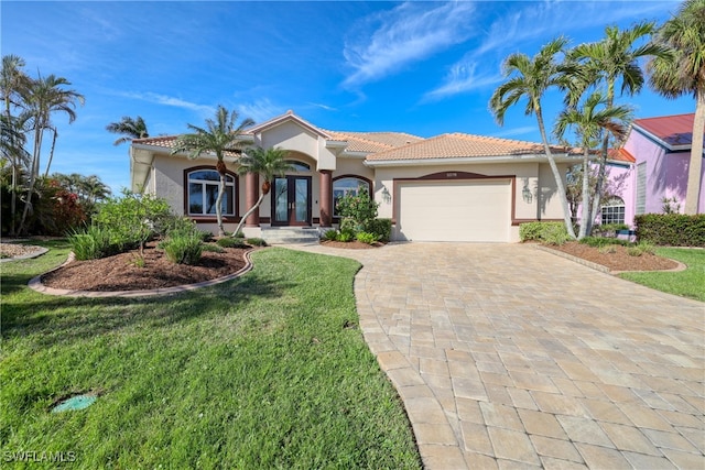 mediterranean / spanish-style house featuring french doors, a front lawn, and a garage