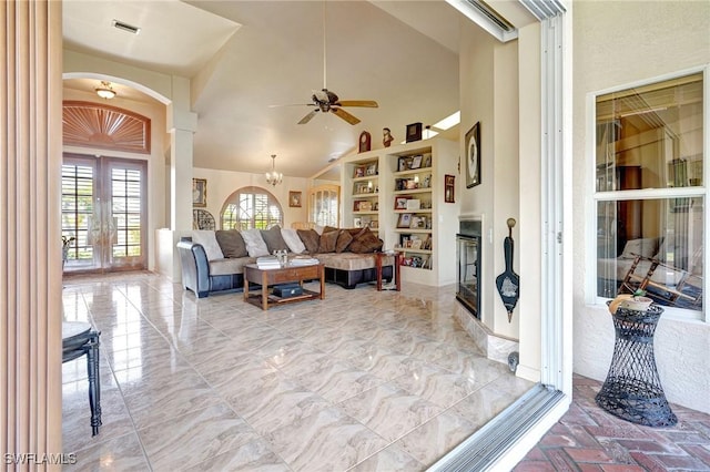 living room featuring french doors, ceiling fan with notable chandelier, and high vaulted ceiling