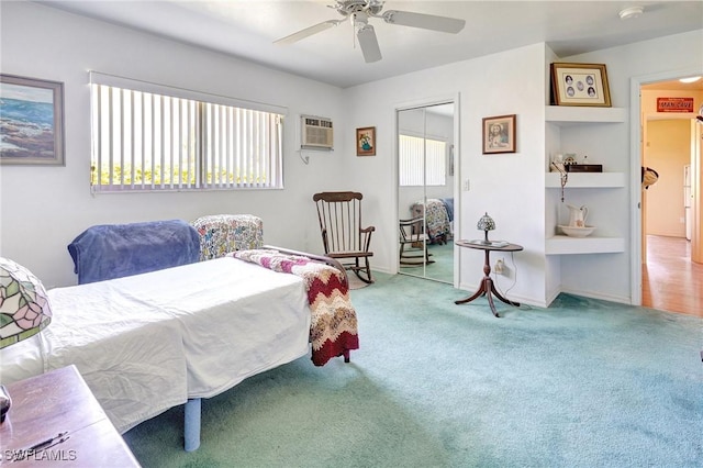 carpeted bedroom with a wall mounted AC, ceiling fan, and a closet