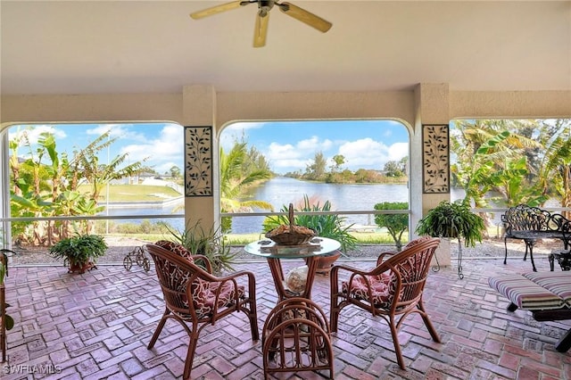 view of patio with ceiling fan and a water view