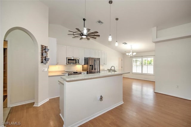 kitchen with lofted ceiling, white cabinetry, a kitchen island with sink, and appliances with stainless steel finishes