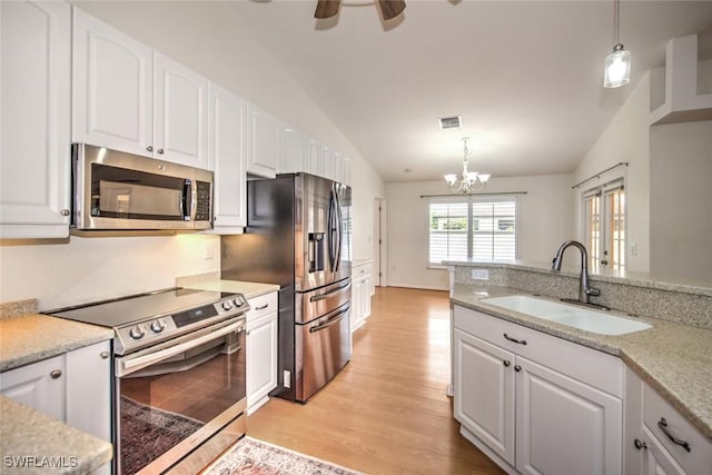 kitchen with white cabinets, appliances with stainless steel finishes, hanging light fixtures, and sink