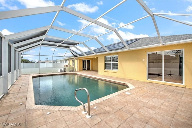 view of pool with glass enclosure and a patio area