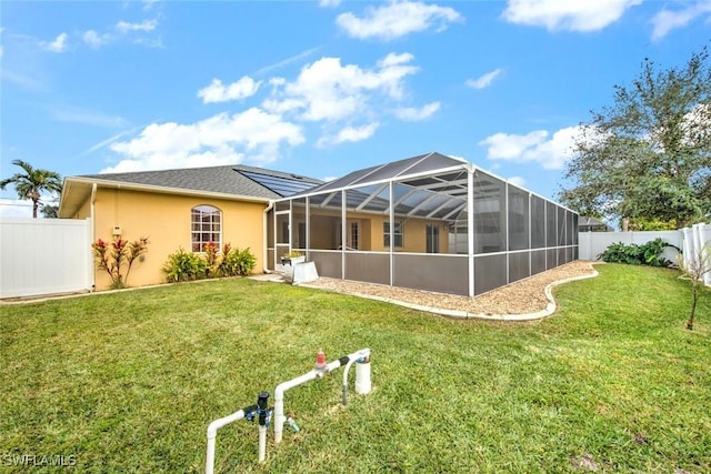 back of property with a lawn and glass enclosure