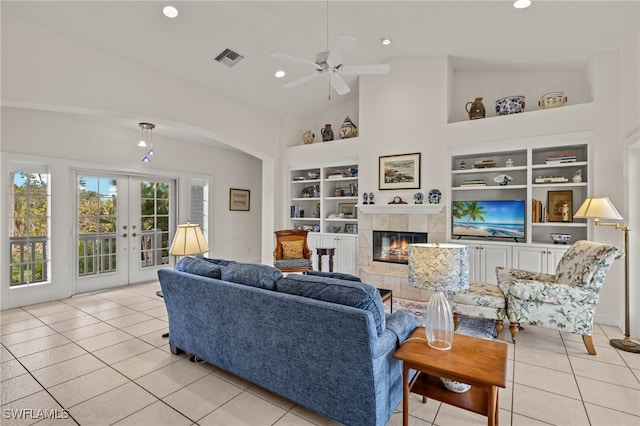 living room featuring ceiling fan, built in features, light tile patterned flooring, and a fireplace