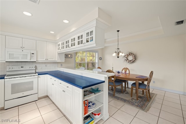 kitchen featuring white appliances, kitchen peninsula, pendant lighting, light tile patterned floors, and white cabinets