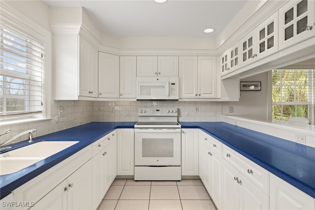 kitchen featuring white appliances, white cabinets, sink, and light tile patterned floors