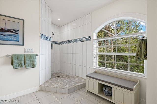 bathroom featuring a tile shower, tile patterned flooring, and a wealth of natural light