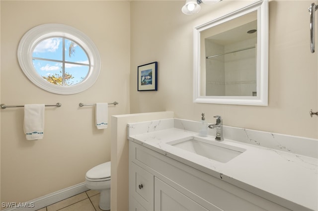 bathroom with toilet, vanity, tile patterned floors, and walk in shower