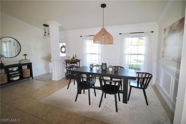 tiled dining space featuring decorative columns, a wealth of natural light, and crown molding