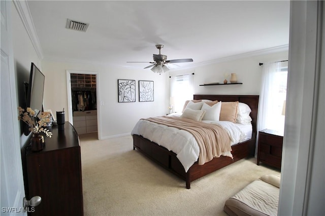 bedroom with light carpet, crown molding, ceiling fan, a spacious closet, and multiple windows