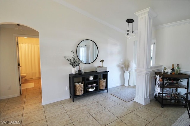 entryway featuring decorative columns, light tile patterned floors, and ornamental molding