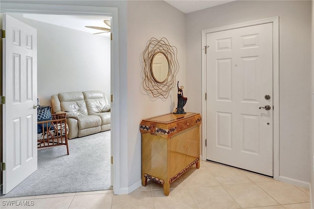 carpeted entryway featuring ceiling fan