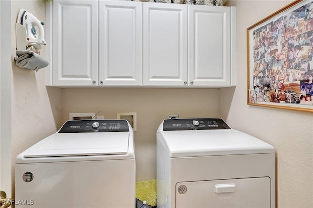 laundry room featuring washing machine and dryer and cabinets