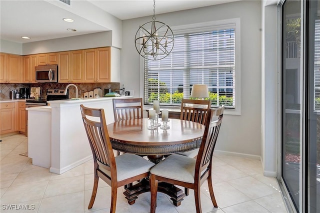 tiled dining room featuring sink and an inviting chandelier