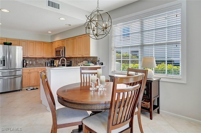 dining space featuring light tile patterned flooring, a chandelier, and a wealth of natural light