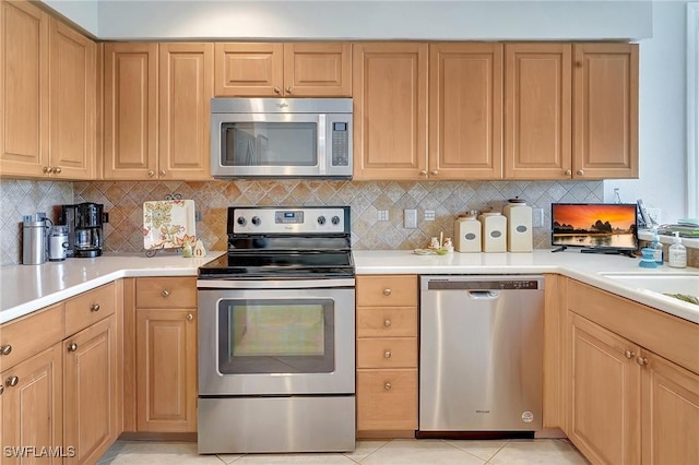 kitchen featuring stainless steel appliances, light tile patterned flooring, decorative backsplash, and sink